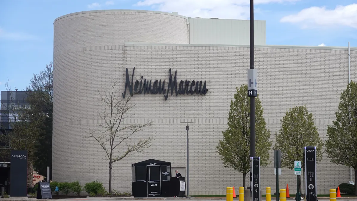 A large, white building with the words Neiman Marcus on the side stands in a parking lot.