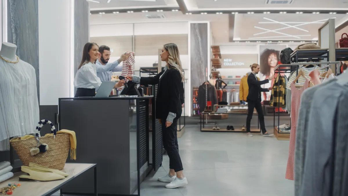 A customer pays for a purchase at a clothing store