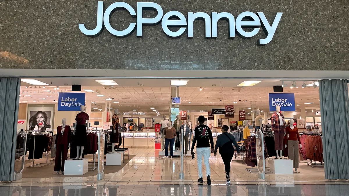 Two people walk into a J.C. Penney retail store.