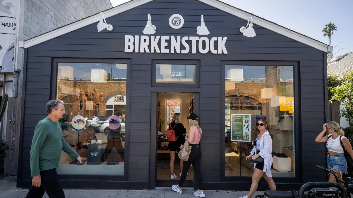 Pedestrians enter a storefront.