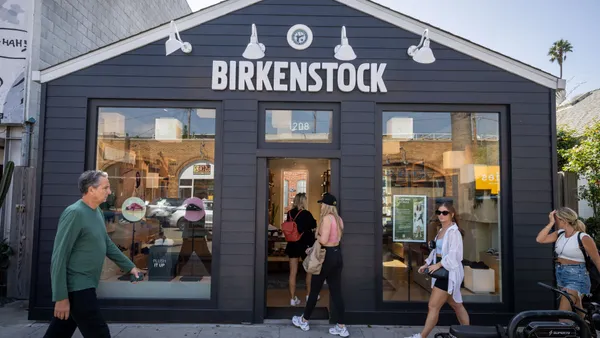 Pedestrians enter a storefront.