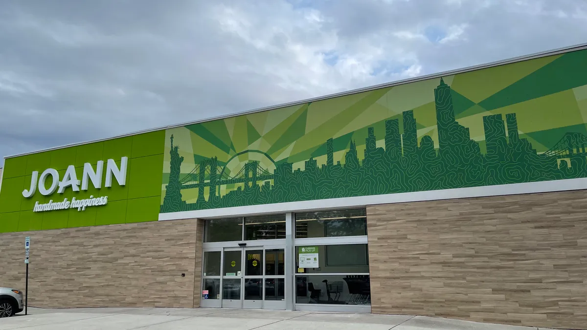 A bright green facade says "Joann" in white capital letters, and "handmade happiness" in white script. A mural in various shades of green depicts a cityscape.