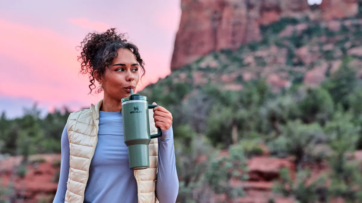 A person holding a Stanley Quencher tumbler.